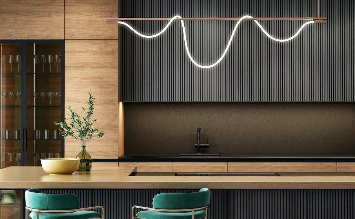 Modern minimalist kitchen with black ribbed paneling, wooden cabinetry, sleek island, and wave-shaped pendant light.